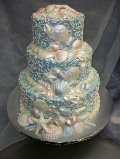 a three tiered cake with seashells on it