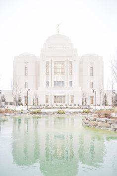 a large white building with a pond in front of it