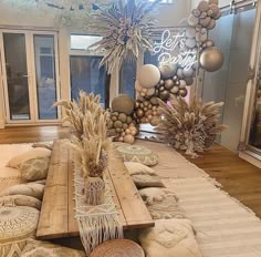 a wooden table sitting on top of a rug covered floor next to pillows and vases