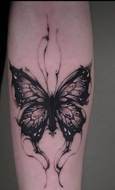 a black and white butterfly tattoo on the leg