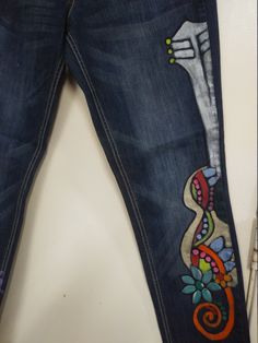 a pair of jeans with embroidered designs on them