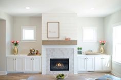 a living room filled with furniture and a fire place in the middle of a room