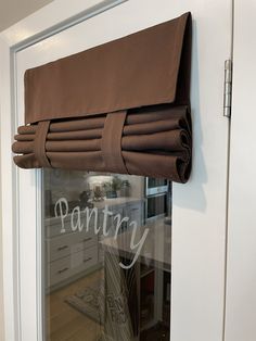 a window with a curtain that has the word pantry written on it in white lettering