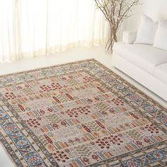 a living room with a white couch and rug on the floor next to a window