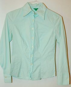 Mint green in color by United Colors of Benneton shoulder to shoulder measured flat is 14 inches underarm to underarm measured flat is 16 inches 22 inch sleeve length 23 inch overall length solid construction and workmanship extra buttons stretch cotton darts in front and back yoke in back detailed center back panel a Benneton classic in excellent condition Cotton Long Sleeve Slim Fit Blouse, Green Slim Fit Button-up Top, Green Slim Fit Button-up Shirt, Stretch Cotton Long Sleeve Shirt, Stretch Cotton Shirt For The Office, Stretch Cotton Shirt For Office, Office Cotton Stretch Shirt, Green Collared Blouse For Office, Green Slim Fit Collared Top