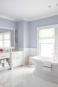 a bathroom with blue walls and white fixtures, including a claw foot tub in the center