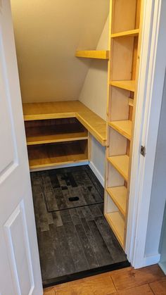 an empty closet with shelves and black tile flooring