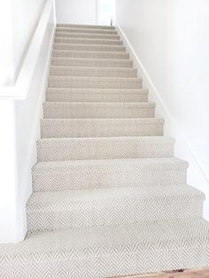 a white staircase with carpeted steps leading up to the door