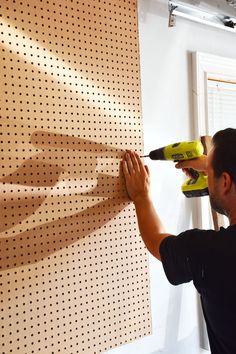 a man is using a drill to cut holes in the wall with a power drill