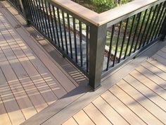 a wooden deck with metal railing and planter box on the top right hand side