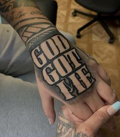 a tattooed hand with the words god over it