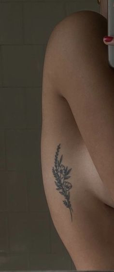 a woman's arm with a tattoo on it and a mirror in the background