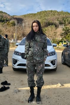 a woman in camouflage standing next to a car