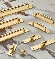 several brass handles and pulls on a marble surface