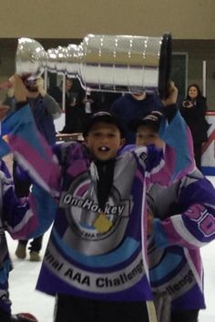 the young hockey players are holding up their trophy