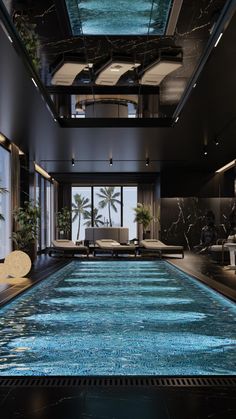 an indoor swimming pool with blue water and palm trees