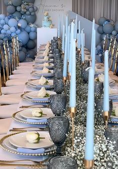 the table is set with blue candles and white plates for an elegant dinner party or celebration