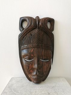 a wooden mask sitting on top of a table