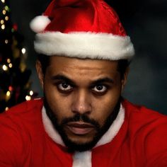 a man wearing a santa hat and looking at the camera with an intense look on his face