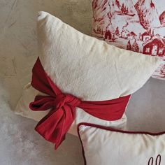 two red and white pillows with bows on them