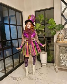 a woman dressed in costume standing next to a potted plant