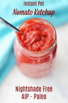 a jar filled with ketchup sitting on top of a table