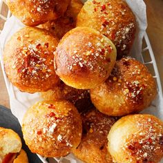 some bread rolls are sitting on a white tray and one is covered in powdered sugar