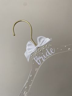 a bridal hanger with a white bow on it's side and the word bride written in cursive font