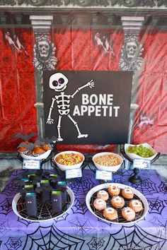 a table topped with lots of food and drinks next to a sign that says bone appetit