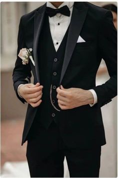 a man in a tuxedo is wearing a white rose boutonniere