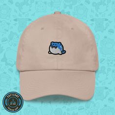 a tan hat with an embroidered blue bird on it's side, against a background of teddy bears