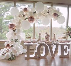 a table topped with lots of white balloons