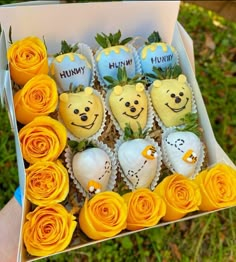 a box filled with lots of yellow cupcakes covered in frosting and flowers