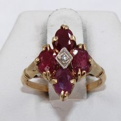 "Rich red rubies accented by a round brilliant diamonds in a 10K yellow gold ring.  Marked 10K.  A wonderful addition to your personal jewelry collection. FREE SHIPPING! Details:  10K Yellow Gold (shown in picture) Natural Ruby: (4) 6 mm x 4 mm oval Approximate Total Gem Weight: 2.4 carats Gem Color: Ruby Red Natural Diamond: (1) 1.5 mm round Diamond Clarity: SI Diamond Color: H Approximate Diamond Weight: 0.02 carat Ring Size: 5 Total Weight: 3.5 grams FREE domestic shipping by USPS Priority Mail Delivery Confirmation. If the item is to be shipped internationally Etsy will calculate postage. Please notify us at purchase if you are buying more than one item and we will gladly combine shipping. 7 day \"no hassle\" return policy money back guarantee. If for any reason you are not 100% thrill Red Ruby Cluster Ring With Rose Cut Diamonds, Fine Jewelry Red Diamond Ring Stamped 14k, Red Diamond Cluster Ring In 14k Gold, Red Cluster Diamond Ring In 14k Gold, Anniversary Red Cluster Ring Stamped 14k, Red Diamond Cluster Ring Stamped 14k, Red Ruby Ring With Diamond Accents In 14k Gold, Red 14k Gold Diamond Ring With Accents, Red Cluster Ring With Diamond Accents For Anniversary