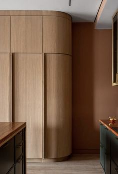 an empty kitchen with wooden cabinets and counter tops in front of a round wall mounted cabinet