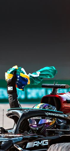 a man standing on top of a racing car