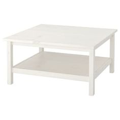 a white coffee table with one shelf on the bottom and an open drawer underneath it