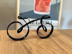 a pair of black metal bicycle sculptures sitting on top of a wooden table