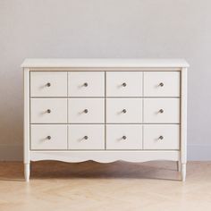 a white dresser sitting on top of a hard wood floor