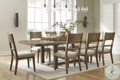 a dining room table and chairs in front of a window with an area rug on the floor