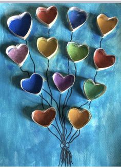 a bunch of heart shaped cookies sitting on top of a blue plate with string attached to it