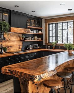 a kitchen with black cabinets and wooden counter tops, along with stools in front of the bar