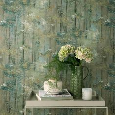 a vase with flowers on top of a table next to a wallpapered background