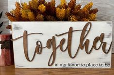 a wooden sign that says together is my favorite place to be on a table with autumn decorations