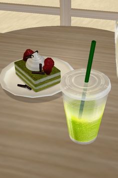 a cup of green tea next to a piece of cake on a plate with a straw