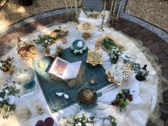 a table topped with lots of different types of flowers and candles on top of a rug