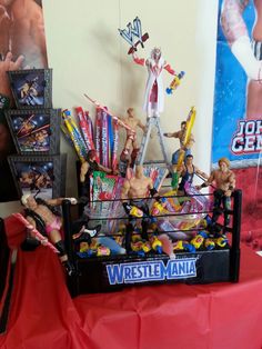 wrestling action figures are on display in the corner of a room with red cloths