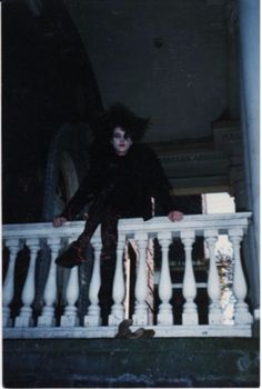 a man sitting on top of a white railing