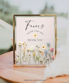 a card with flowers on it sitting on top of a wooden table