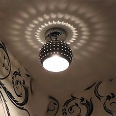 the light is shining on the ceiling in the room with black and white wallpaper